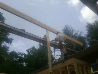 Carpenter setting a ridge beam over a new addition frame — Ice Dam Removal by Roofing Brothers in Huger