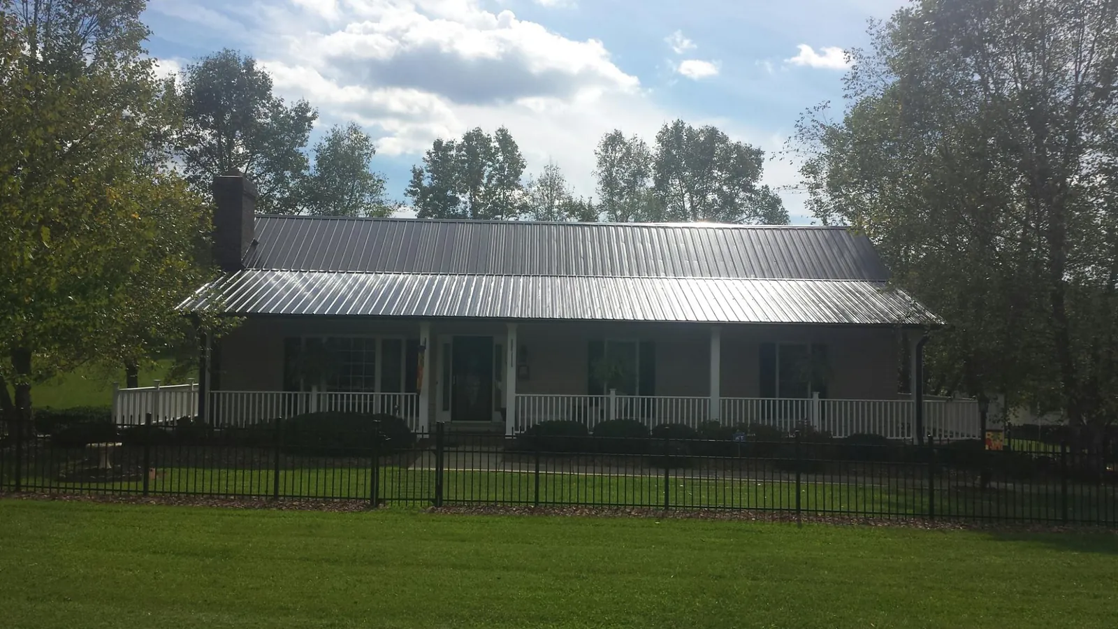 Gray metal roof on a brick ranch with a full width front porch — Gutter Guard Installation work by our crew in Huger