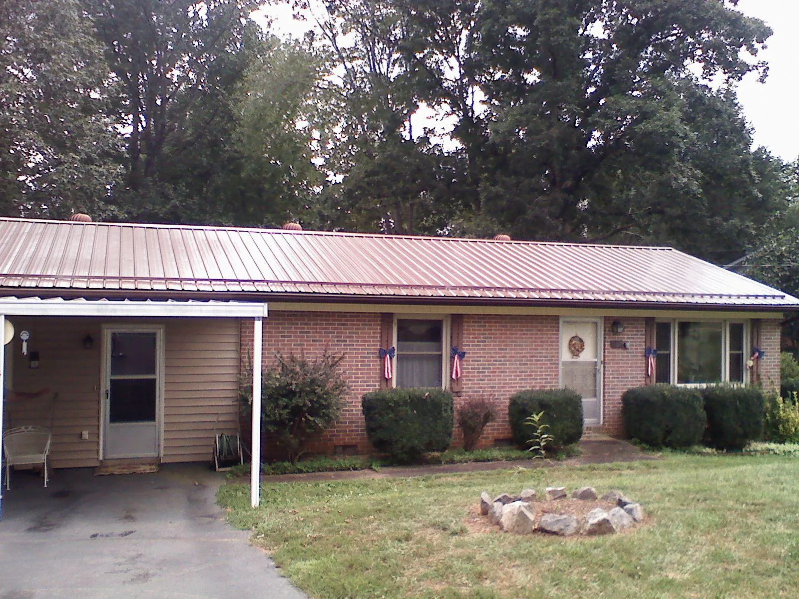 Bronze metal roof and carport on a brick ranch home — Roof Repair work by our crew in Huger