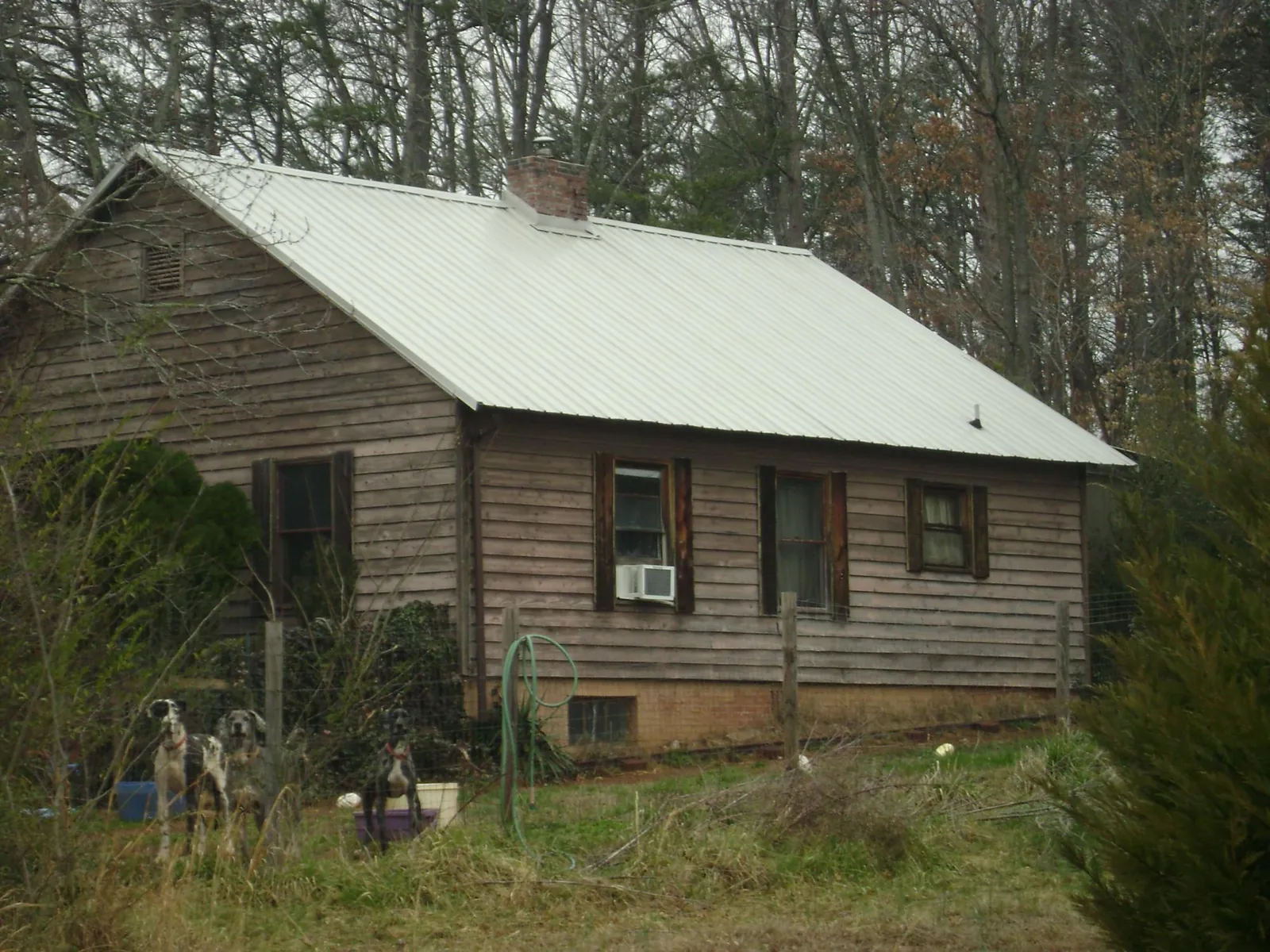 White metal roof on an old wood sided farmhouse, from a Metal Roof Installation job in Huger